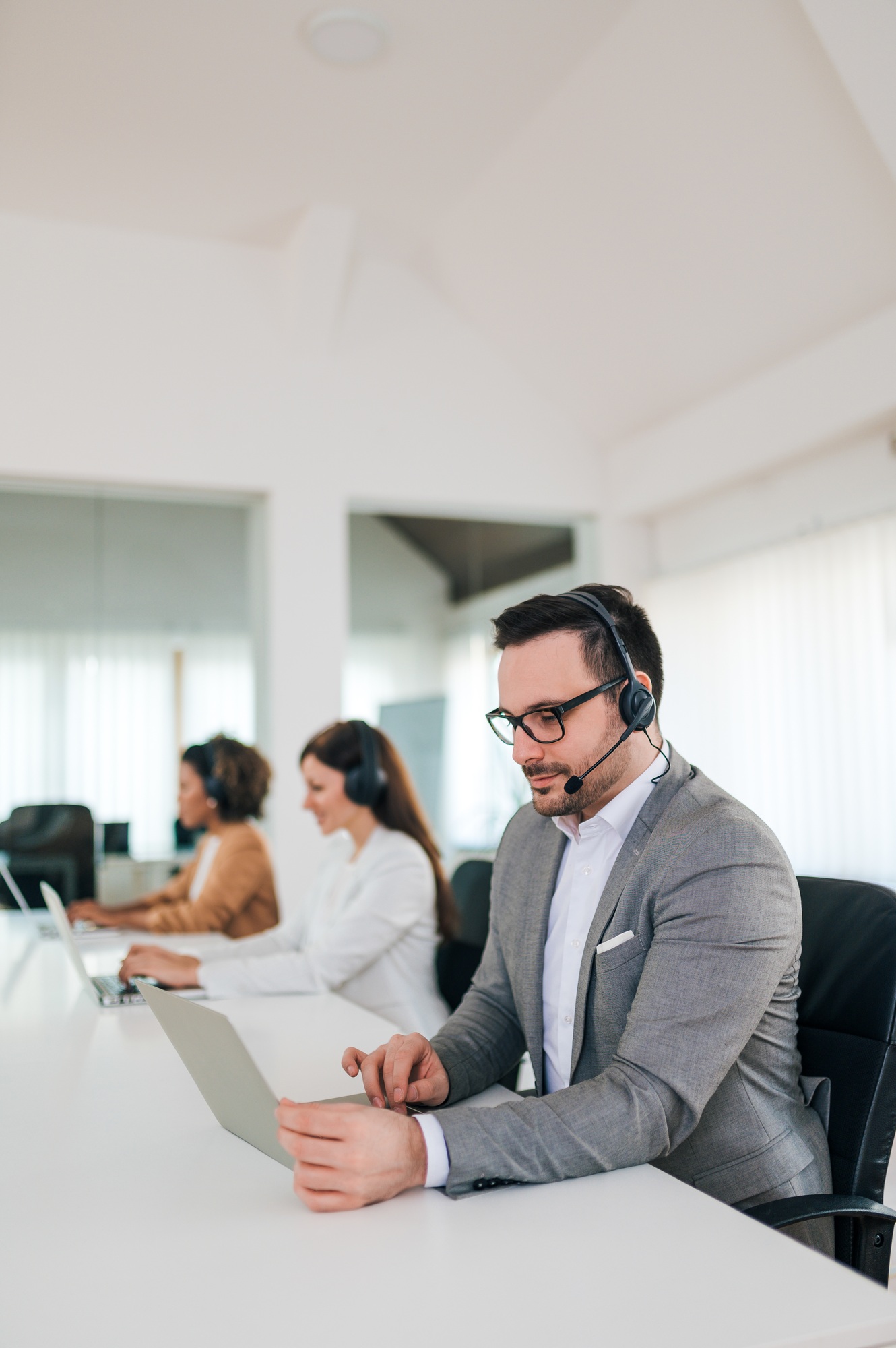 Portrait of a handsome customer support phone operator at workplace.