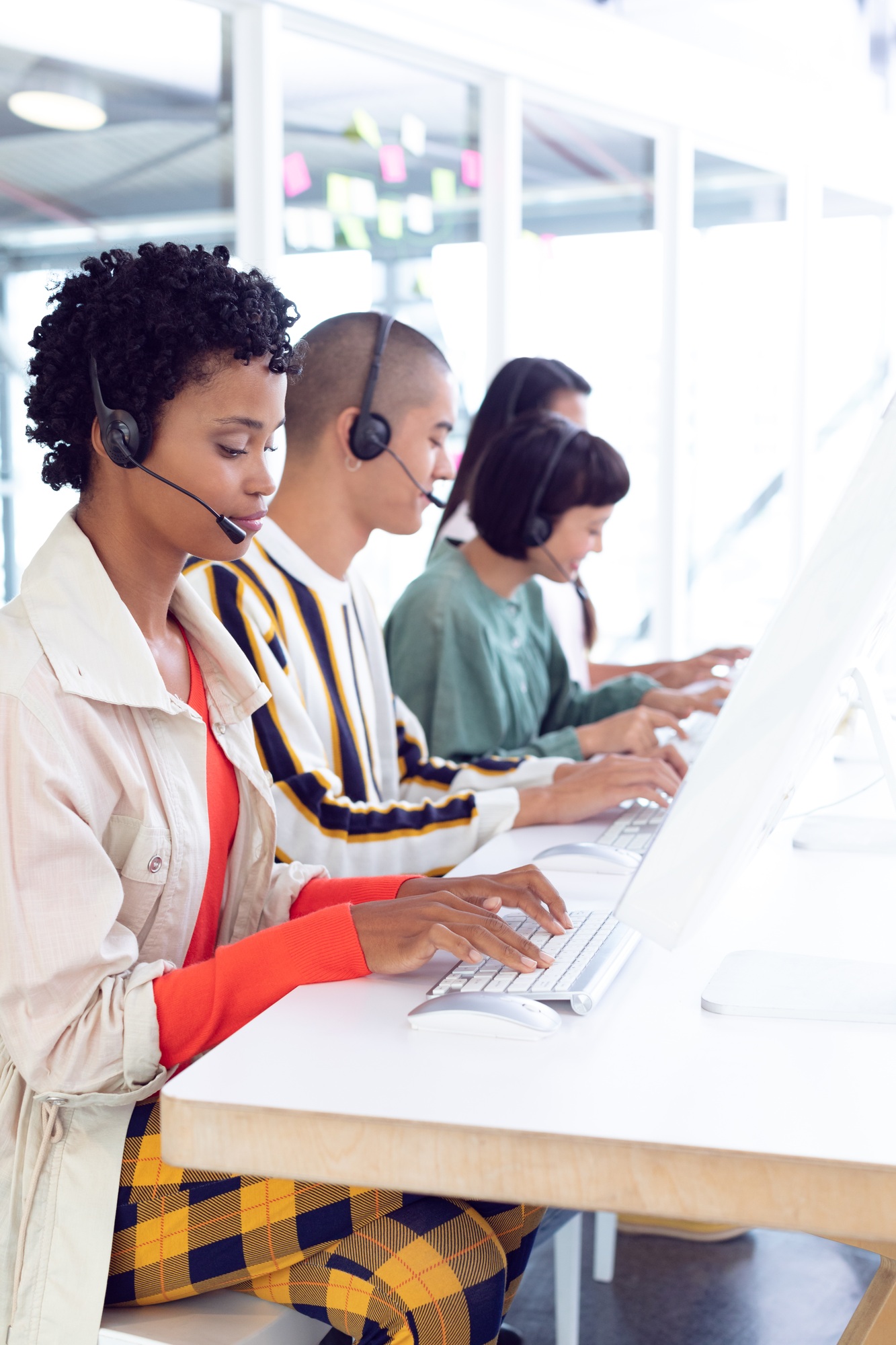 Side view of diverse customer service executives working on computer at desk in office
